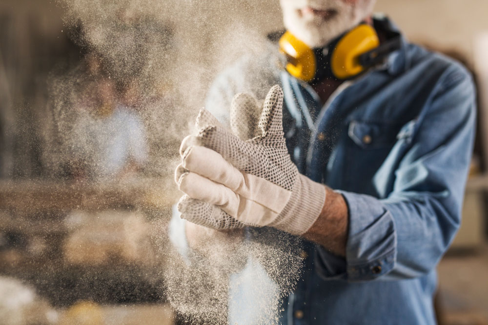 Un ouvrier frotte ses gants de travail pour les nettoyer