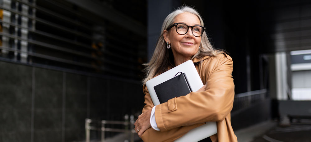 portrait d'une femme d'affaires âgée avec un ordinateur portable à lunettes à l'extérieur du bureau, concept de femme forte et indépendante