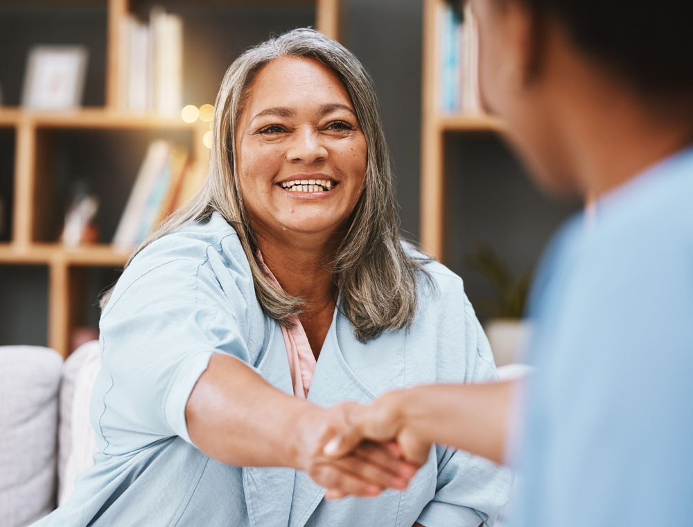 Poignée de main, soins de santé et rendez-vous avec une femme âgée serrant la main à une infirmière dans une maison de retraite. Merci, soins médicaux et rendez-vous avec un patient d'âge mûr et un professionnel de la médecine